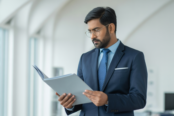 Indian business owner reviewing environmental compliance documents in a modern office setting